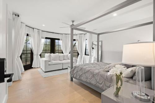 ein weißes Schlafzimmer mit einem Bett und einem Sofa in der Unterkunft Mansion Wifi Fire Pit Sleeps 14 in Dedham