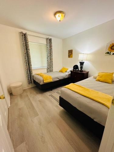 a bedroom with two beds with yellow pillows at Feels like HOME escape, 1/2 Mile to beach in Gulfport
