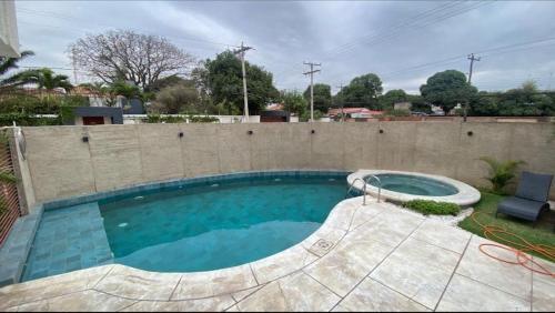 una piscina frente a una pared de ladrillo en ApartHotel JH 2, en Santa Cruz de la Sierra