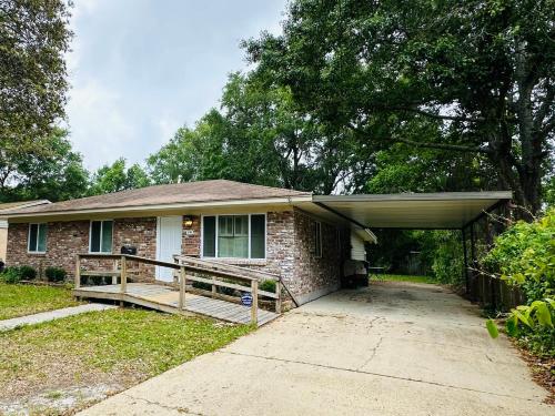 a brick house with a porch and a garage at Feels like HOME escape, 1/2 Mile to beach in Gulfport