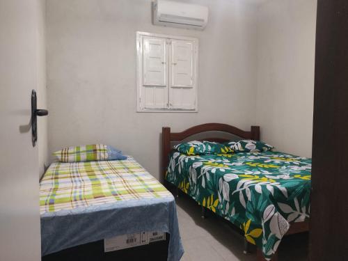 a bedroom with two beds and a window at Casa perto do Centro de Convenções in Recife