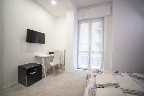 Dormitorio con cama, escritorio y TV en Residenza Ponte Catena, en Verona