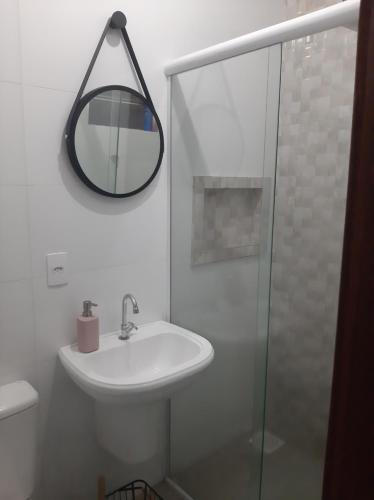 a white bathroom with a sink and a mirror at Casa completa perto da praia in Florianópolis