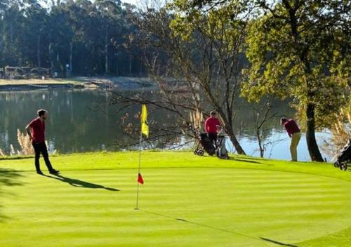 a group of people playing golf on a golf course at Casa by Anita Guesthouse in Esposende