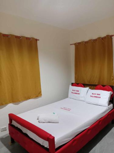 a bedroom with a large bed with red and white pillows at Wjv Inn Talamban in Cebu City