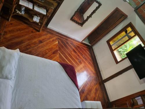 a room with a bed and wooden floors and a window at Rancho Mi Cielo 