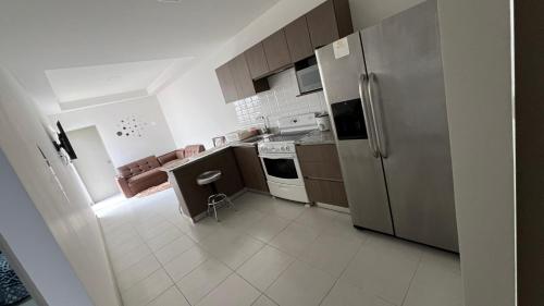 een keuken met een roestvrijstalen koelkast en kasten bij Apartamento condominio alajuela in San Antonio