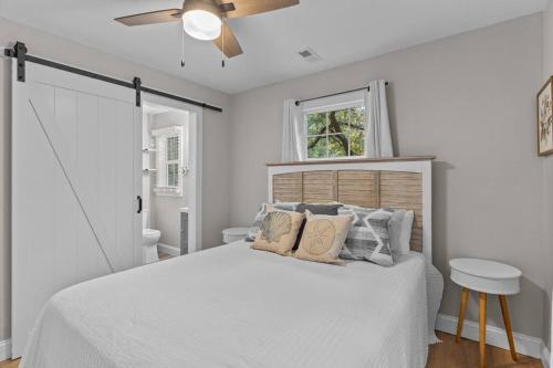a white bedroom with a bed and a ceiling fan at The Blue Wave Quiet & Cozy Beach Retreat in Oak Island