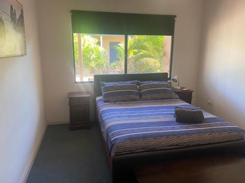um quarto com uma cama grande e uma janela em Ningaloo Breeze Villa 3 em Exmouth