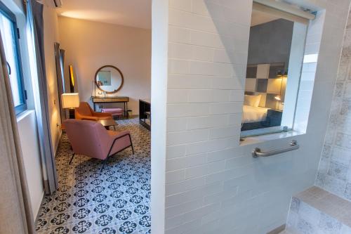 a hotel room with a chair and a mirror at ACQUA IN BOCCA in Mérida