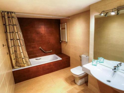 ein Badezimmer mit einer Badewanne, einem WC und einem Waschbecken in der Unterkunft Villa Vall-llòbrega, 5 dormitorios, 10 personas - ES-329-7 in Vall-llobrega