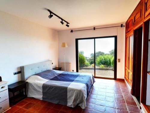ein Schlafzimmer mit einem Bett und einem großen Fenster in der Unterkunft Villa Platja d'Aro, 4 dormitorios, 10 personas - ES-329-30 in Castillo de Aro
