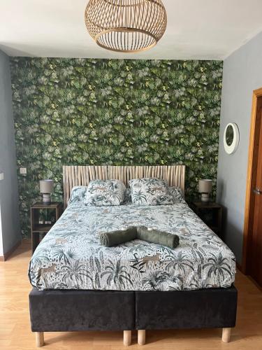 a bedroom with a bed with a floral wall at Studio tropical baie des citrons in Noumea