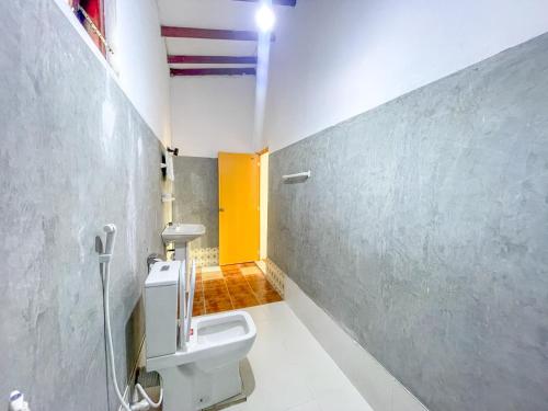 a bathroom with a toilet and a yellow door at Summer lodge-Tangalle in Tangalle
