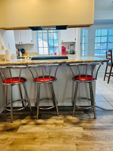 a kitchen with two bar stools at a counter at Casa Feliz Arizona in Fort Mohave