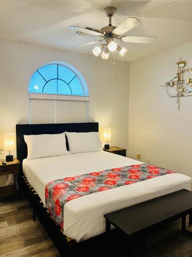a bedroom with a bed with a ceiling fan and a window at Casa Feliz Arizona in Fort Mohave