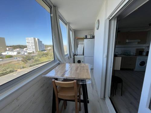 une table et des chaises dans une pièce avec une grande fenêtre dans l'établissement Studio charmant proche plage avec animaux admis - FR-1-324A-66, à Saint-Hilaire-de-Riez