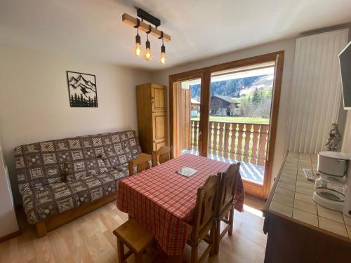 une salle à manger avec une table et un balcon dans l'établissement Appartement 2 pièces avec balcon sud, parking et cave à La Chapelle-d'Abondance - FR-1-692-99, à La Chapelle-dʼAbondance