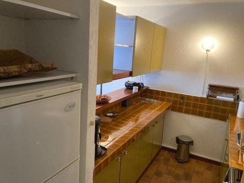 une cuisine avec des armoires jaunes et un comptoir dans l'établissement Appartement Climatisé, Traversant avec Parking Privé - Centre Ville Le Lavandou - FR-1-308-193, au Lavandou