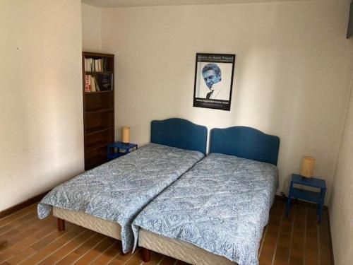 un lit dans une chambre avec un tableau sur le mur dans l'établissement Appartement Climatisé, Traversant avec Parking Privé - Centre Ville Le Lavandou - FR-1-308-193, au Lavandou