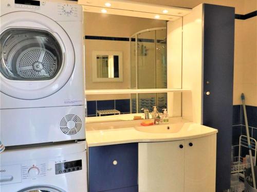 une salle de bain avec une machine à laver et un lavabo dans l'établissement Bel appartement au centre de Royan avec balcon, garage et ascenseur - FR-1-494-188, à Royan