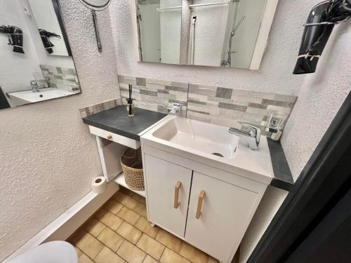 une salle de bain avec un lavabo et un miroir dans l'établissement Studio 4 Personnes avec Piscine et Terrasse près de la Plage au Grau-du-Roi - FR-1-716-74, au Grau-du-Roi