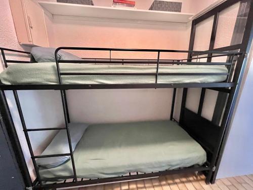 quelques lits superposés dans une chambre dans l'établissement Studio 4 Personnes avec Piscine et Terrasse près de la Plage au Grau-du-Roi - FR-1-716-74, au Grau-du-Roi