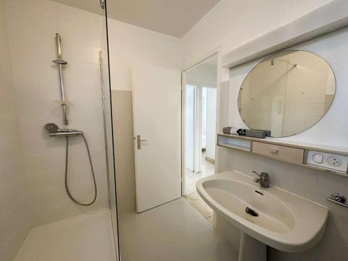 une salle de bain avec une douche, un lavabo et un miroir dans l'établissement Appartement rénové en bord de mer avec terrasse - 4 pers, proche plage et port - FR-1-481-162, à La Forêt-Fouesnant
