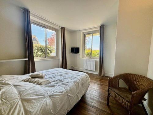 - une chambre avec un lit, une chaise et deux fenêtres dans l'établissement Appartement T5 lumineux avec jardin privé et terrasse, proche plage - 8 pers. - FR-1-478-282, à Quiberon