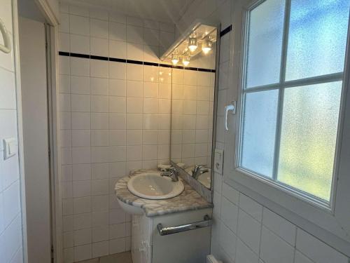 une salle de bain avec un lavabo et des toilettes et une fenêtre dans l'établissement Maison calme proche plage avec jardin clos, parking privé & barbecue – L'Épine - FR-1-224B-221, à LʼÉpine