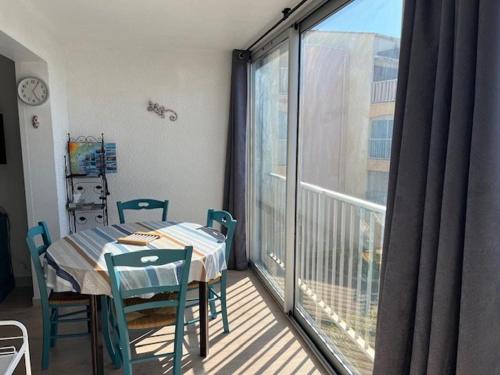 Cette chambre dispose d'une table, de chaises et d'un balcon. dans l'établissement Magnifique T3 rénové pour 4 pers. à Agde, proche plage, parking privé - FR-1-749-58, au Cap d'Agde