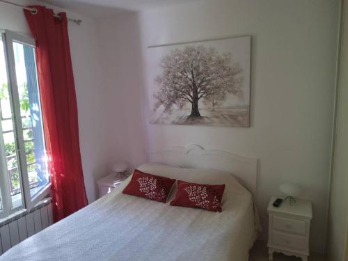 une chambre avec un lit avec deux oreillers rouges dessus dans l'établissement Appartement F2 ensoleillé avec terrasse et parking, proche des Thermes et centre-ville - FR-1-703-178, à Amélie-les-Bains-Palalda