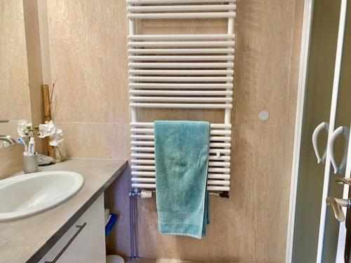 une salle de bain avec une serviette accrochée à un porte-serviettes dans l'établissement Appartement F2 ensoleillé avec terrasse et parking, proche des Thermes et centre-ville - FR-1-703-178, à Amélie-les-Bains-Palalda