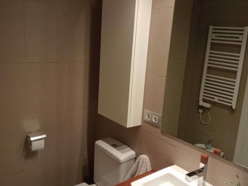 een badkamer met een toilet, een wastafel en een spiegel bij Apartamento Platja d'Aro, 2 dormitorios, 4 personas - ES-209-77 in Madrid