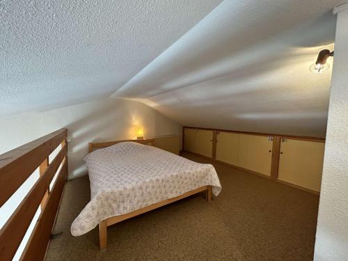 une petite chambre avec un lit dans un grenier dans l'établissement Appartement 2 pièces avec mezzanine, 4 couchages, balcon, parking, à 100m de la mer, Saint-Jean-de-Monts - FR-1-224C-295, à Saint-Jean-de-Monts