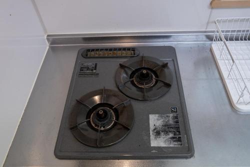 a stove top with two burners on top of it at apartment hotel myu in Mito