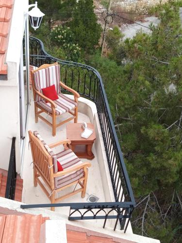 a balcony with two chairs and a coffee table at Arcadia Guesthouses - Ghazir, Lebanon in Ed Dkârîne