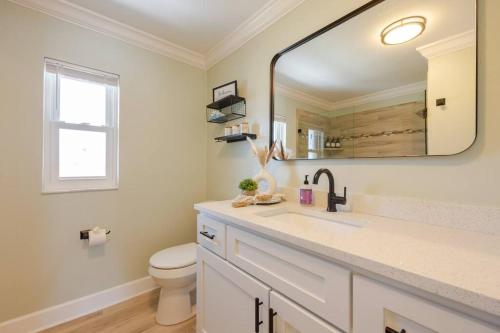 a bathroom with a sink and a toilet and a mirror at Oceanview Retreat/Perfect for Groups/Heated Pool in Fort Myers Beach