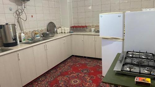 uma cozinha com um frigorífico branco e um piso vermelho em Villa del Prio em Priozersk