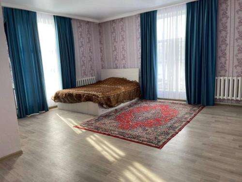 um quarto com uma cama com cortinas azuis e um tapete em Villa del Prio em Priozersk