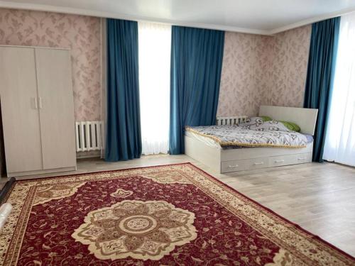 um quarto com uma cama com cortinas azuis e um tapete em Villa del Prio em Priozersk