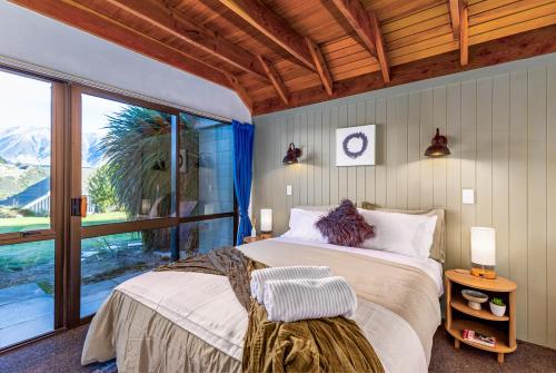 1 dormitorio con cama y ventana grande en Rakaia Gorge Views - Mt Hutt, en Windwhistle