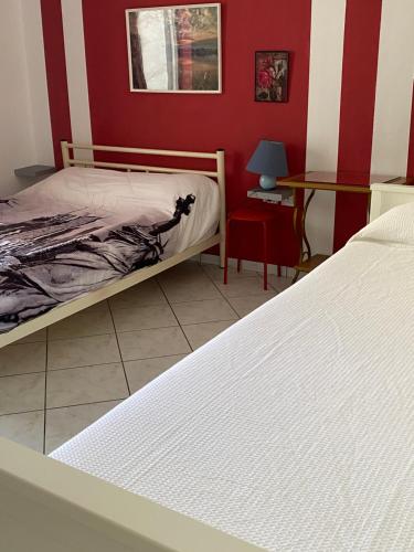 a bedroom with a bed and a red wall at Igoumenitsa heart flats to let Mariasroom studios appart seaside-city Spyropoulos in Igoumenitsa