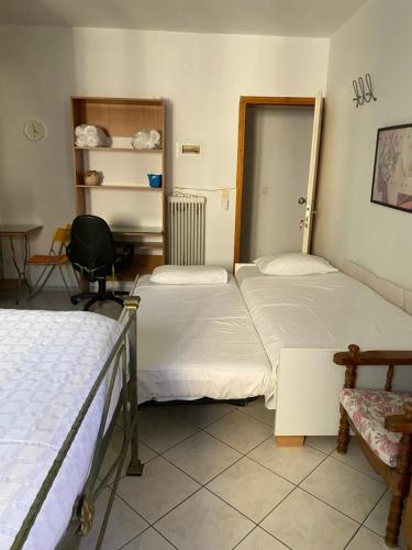 a room with two beds and a chair and a table at Igoumenitsa heart flats to let Mariasroom studios appart seaside-city Spyropoulos in Igoumenitsa