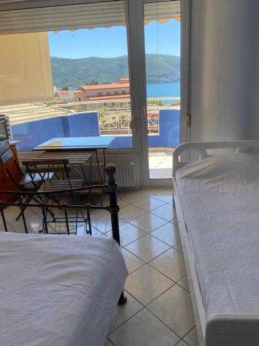 a room with a table and a bed and a window at Igoumenitsa heart flats to let Mariasroom studios appart seaside-city Spyropoulos in Igoumenitsa