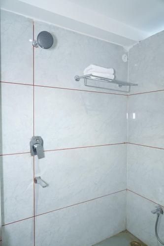 La salle de bains est pourvue d'une douche avec un pommeau de douche. dans l'établissement Royal Chandra Hotel, à Patna