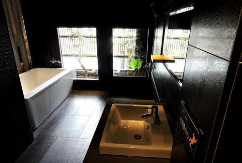 a bathroom with a sink and a bath tub at Roppongi Motel - Dalian in Pingtung City
