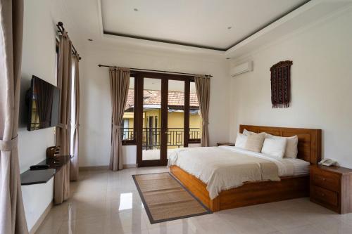 a bedroom with a bed and a television in it at Kubu Bali Baik Villa & Resort - CHSE Certified in Ubud