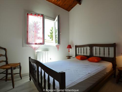 une chambre avec un lit avec des oreillers orange et une fenêtre dans l'établissement Belle villa 4 pièces, 7 pers., proche mer et commerces, La Palmyre, avec patio, jardin, animaux admis - FR-1-705-68, aux Mathes