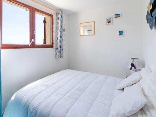 une chambre avec un lit blanc avec une fenêtre dans l'établissement Appartement T2 avec balcon, parking privé, petit animal admis - FR-1-409-266, à Fleury